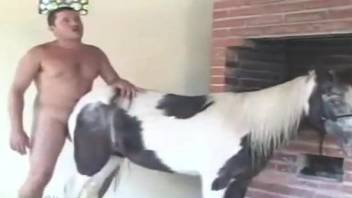 Impressive white horse and horny man are screwing in doggy pose