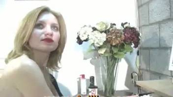A fair-haired woman with crimson lips treats her dominant older partner to a pleasurable blowjob.