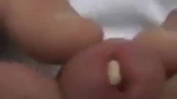 Aroused guy inserts a worm into his dick for added ecstasy