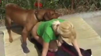 Blonde dressed in green gets banged by a dog